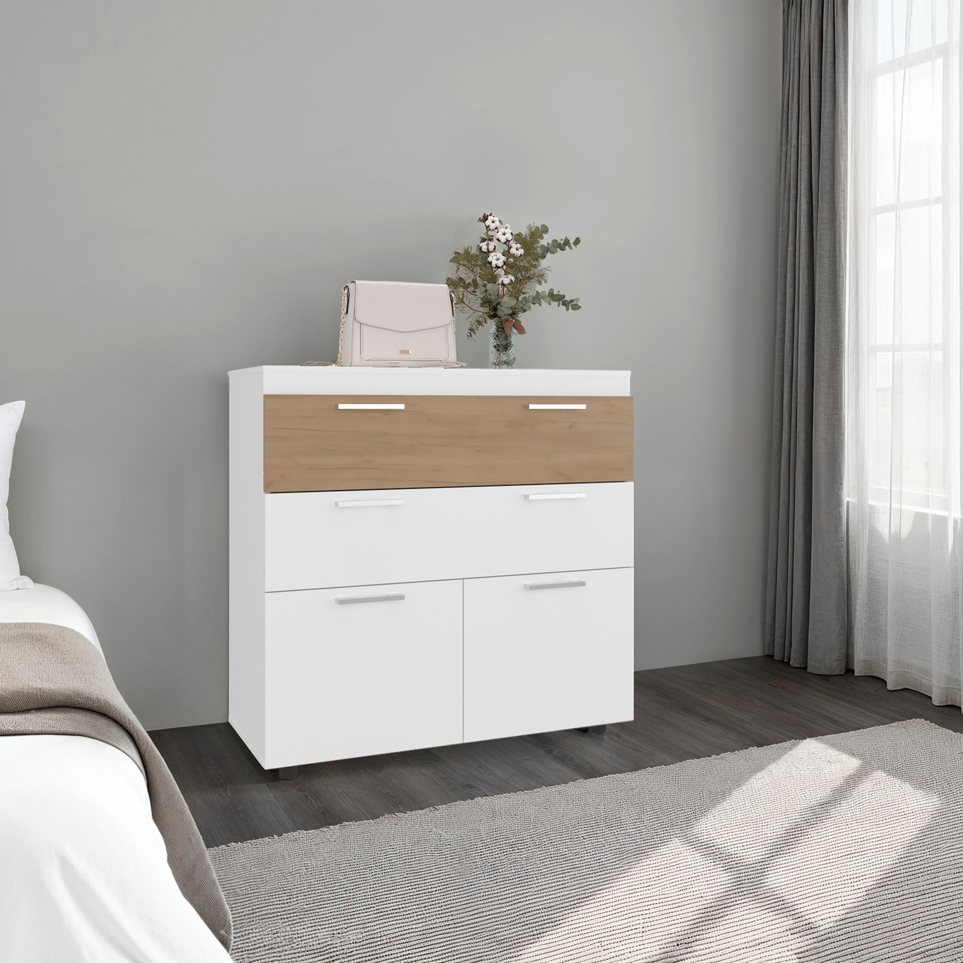 White and wood dresser in a bedroom with a bed and window in the background