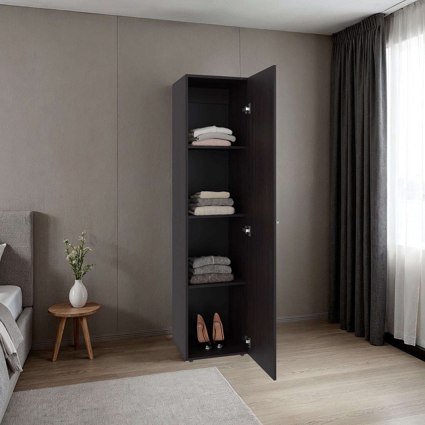Black wardrobe with open doors in a bedroom setting